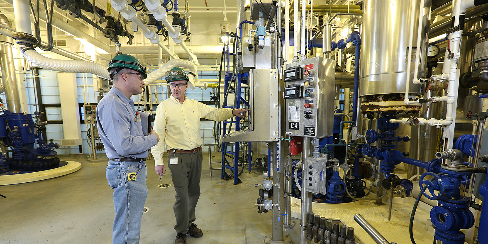 Two employees working in chemical manufacturing plant